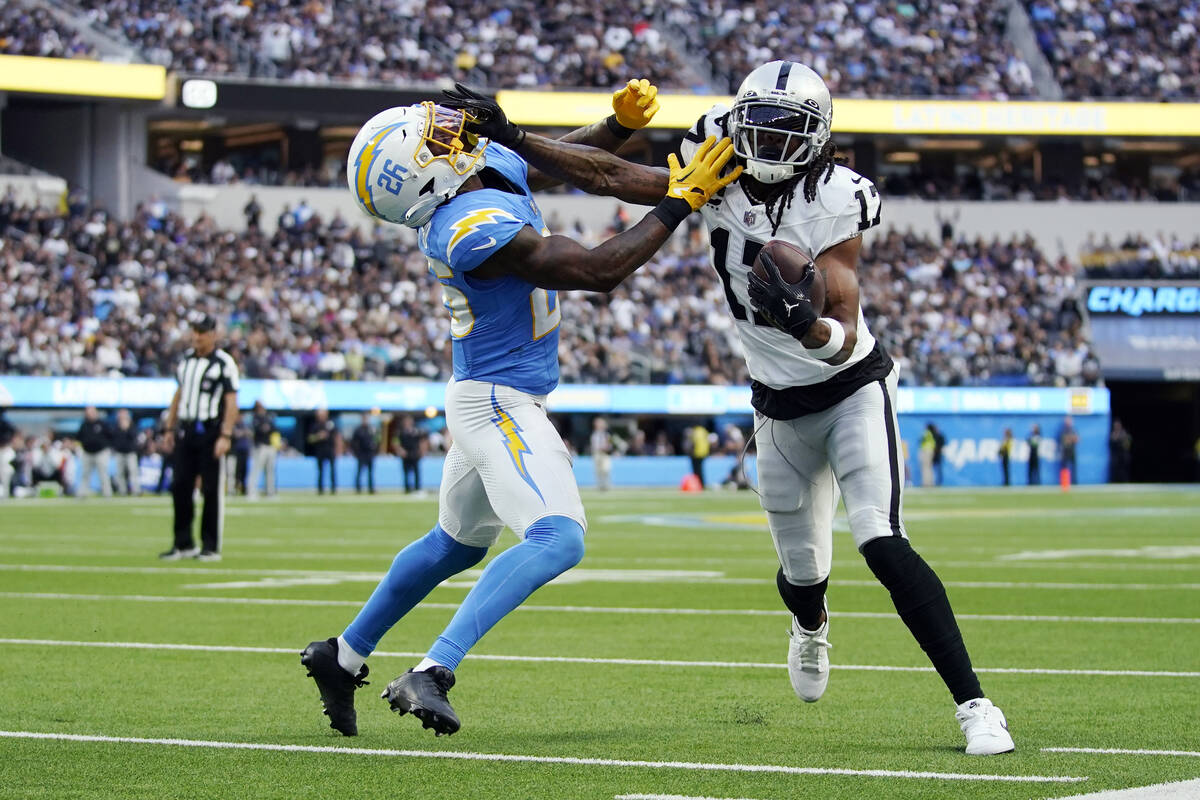Las Vegas Raiders wide receiver Davante Adams (17) stiff-arms Los Angeles Chargers cornerback A ...