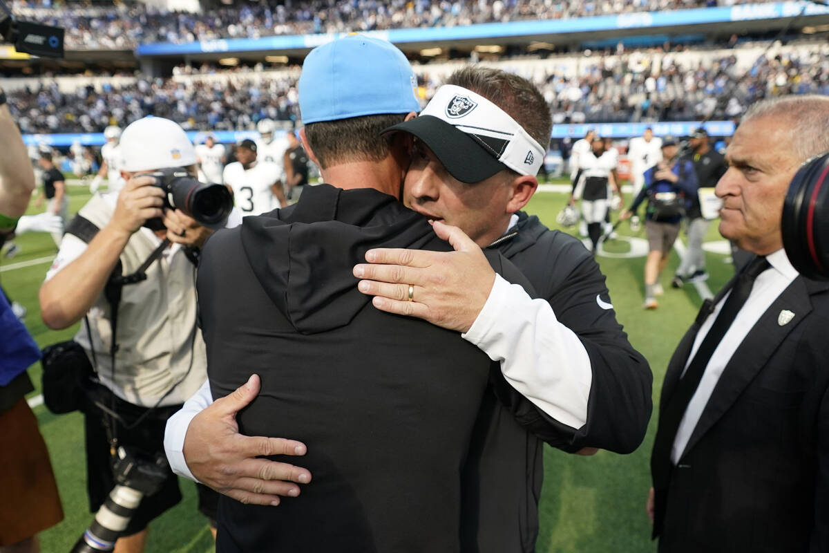 Las Vegas Raiders head coach Josh McDaniels, right, hugs Los Angeles Chargers head coach Brando ...