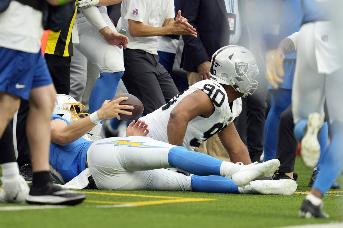 Las Vegas Raiders defensive tackle Jerry Tillery, right, hits Los Angeles Chargers quarterback ...