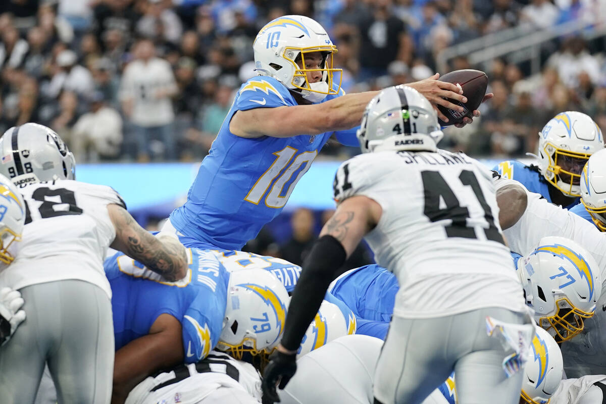 Los Angeles Chargers quarterback Justin Herbert (10) lunges into the end zone for a touchdown d ...