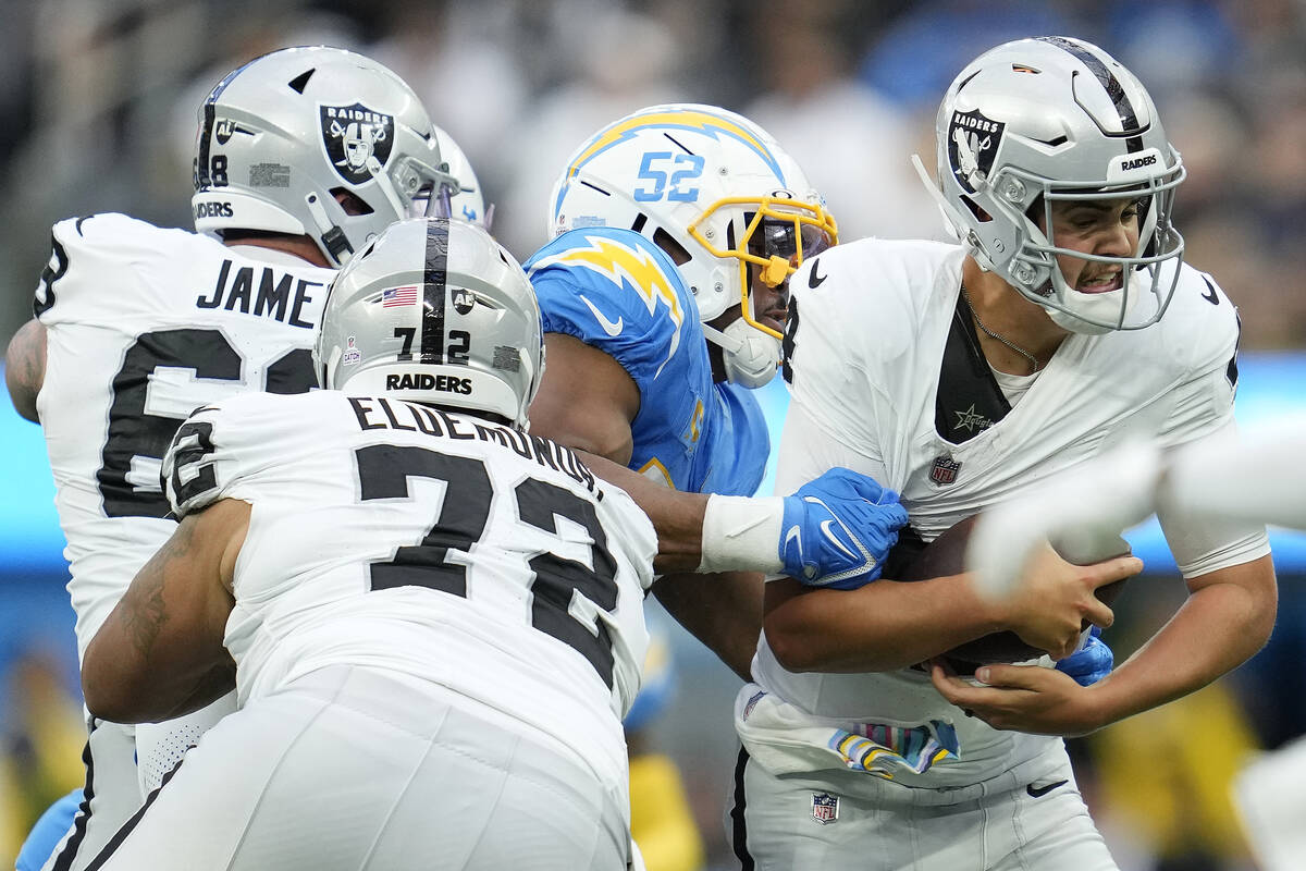 Las Vegas Raiders quarterback Aidan O'Connell, right, is sacked by Los Angeles Chargers linebac ...