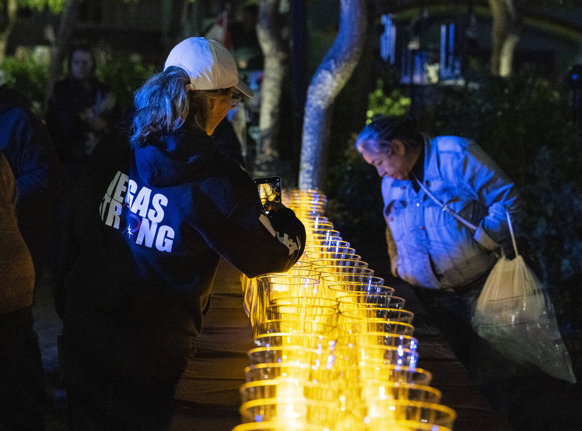 Mynda Smith, left, sister of shooting victim Neysa Tonks, takes a picture of lit candles after ...