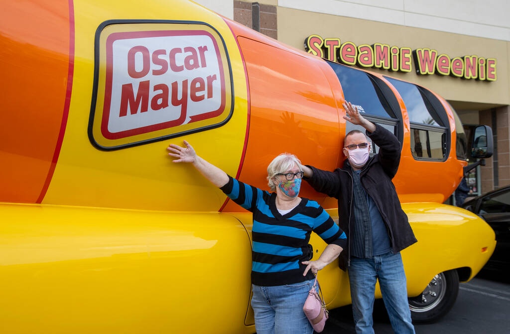 Candy Ochs, left, and Russ Reynolds pose beside the Oscar Mayer Wienermobile parked outside the ...