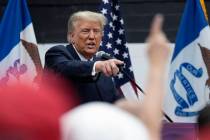 Former President Donald Trump visits with campaign volunteers in Iowa. (AP Photo/Charlie Neiber ...