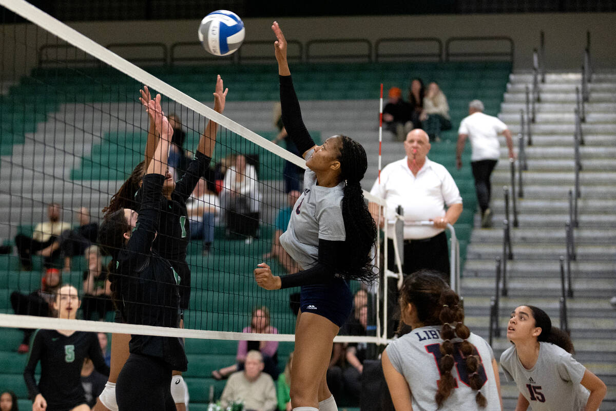 Liberty’s Alex Walker (2) spikes while Palo Verde’s Taylor Mendez, left, and Kari ...