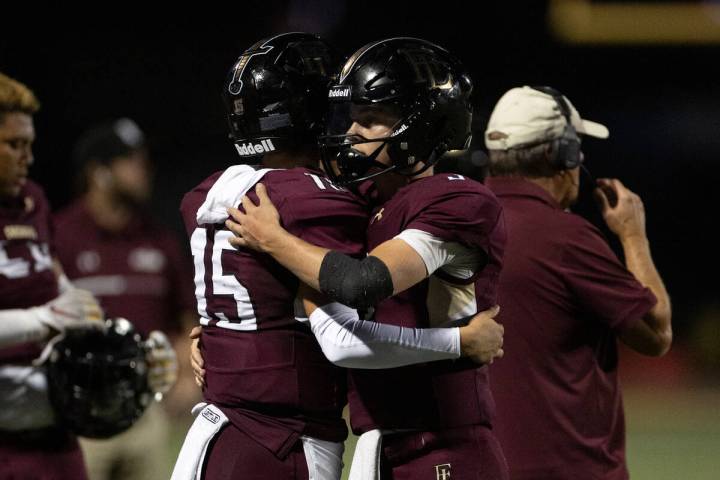 Faith Lutheran quarterbacks Alex Rogers (15) and Garyt Odom (3) embrace during a high school fo ...
