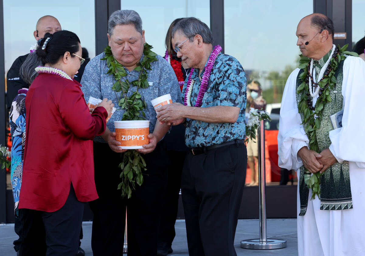 CEO Jason Higa, center, receives dirt from the Paiute Tribe and Hawaii during the grand opening ...
