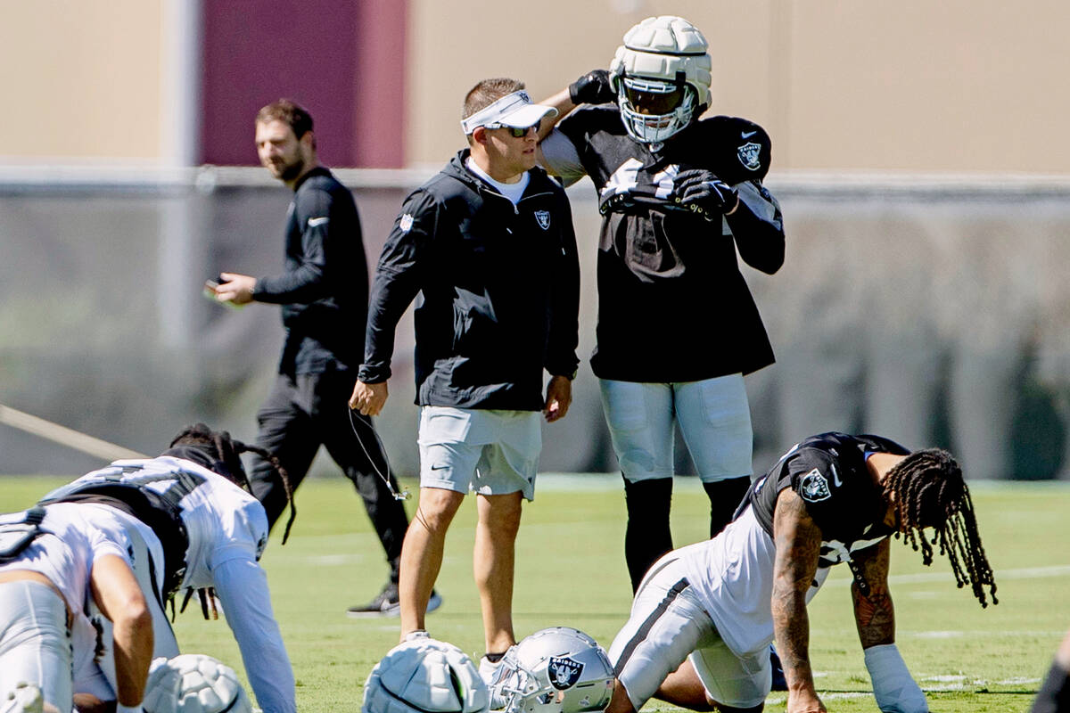 Raiders head coach Josh McDaniels speaks to linebacker Robert Spillane (41) during the team&#x2 ...