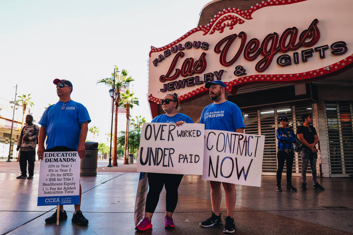 Demonstrators watch as a crowd marches in support of the Clark County Education Association at ...