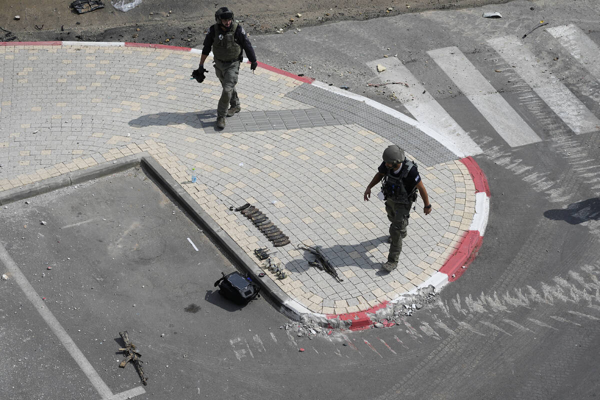 Israeli police retrieve weapons used by militants outside a police station that was overrun by ...