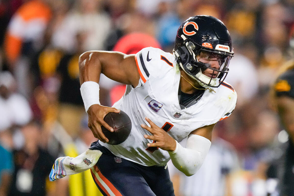 Chicago Bears quarterback Justin Fields (1) runs with the ball during the second half of an NFL ...