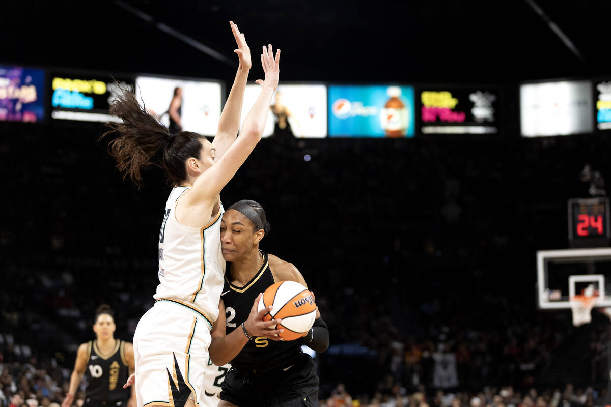 Las Vegas Aces forward A'ja Wilson (22) powers through defense by New York Liberty forward Brea ...