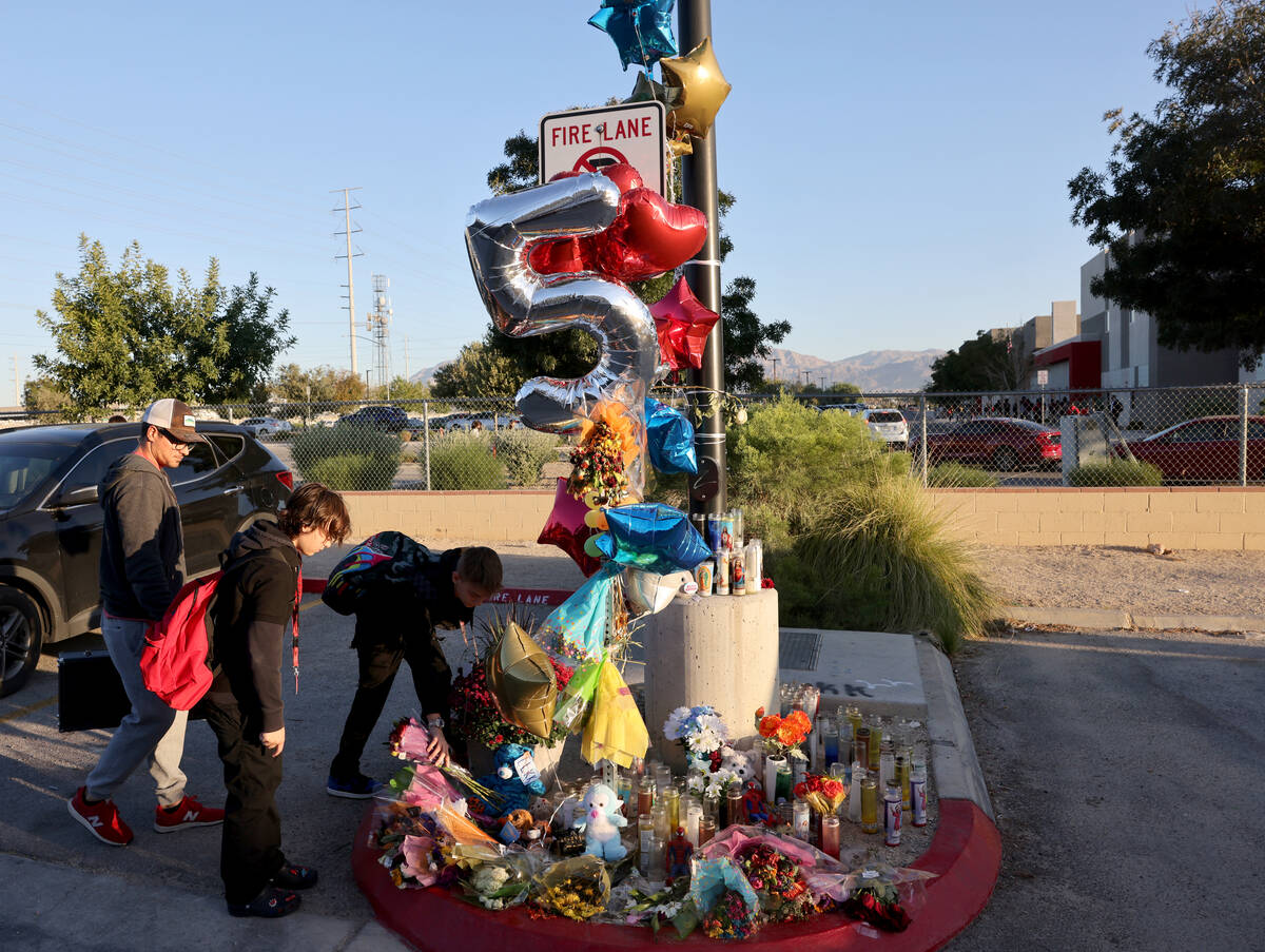 Peter Kinum, from left, his stepdaughter Lyla Huthpast, 13, and son Sawyer Kinum, 12, lay flowe ...