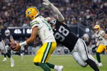 The Green Bay Packers quarterback Jordan Love (10) tries to avoid a tackle from Raiders defensi ...