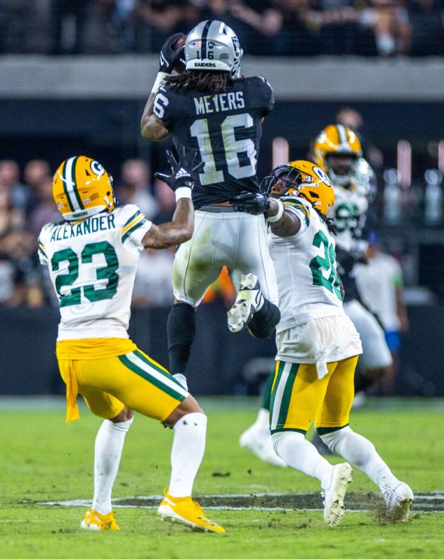 Raiders wide receiver Jakobi Meyers (16) elevates for a reception over Green Bay Packers runnin ...
