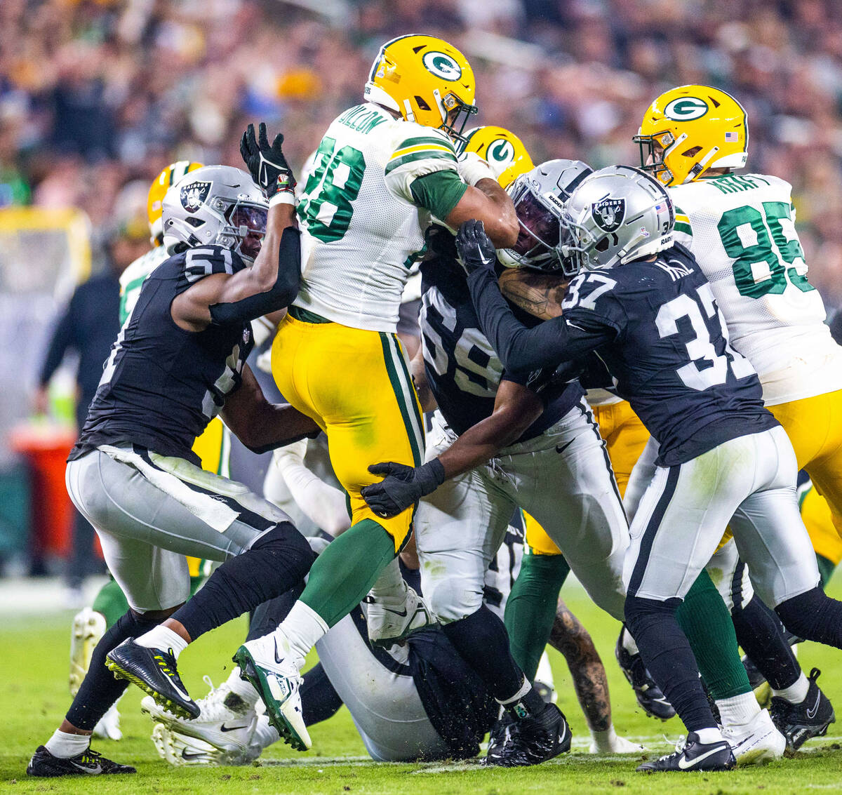 Green Bay Packers running back AJ Dillon (28) is gang tackled by Raiders defensive tackle Adam ...