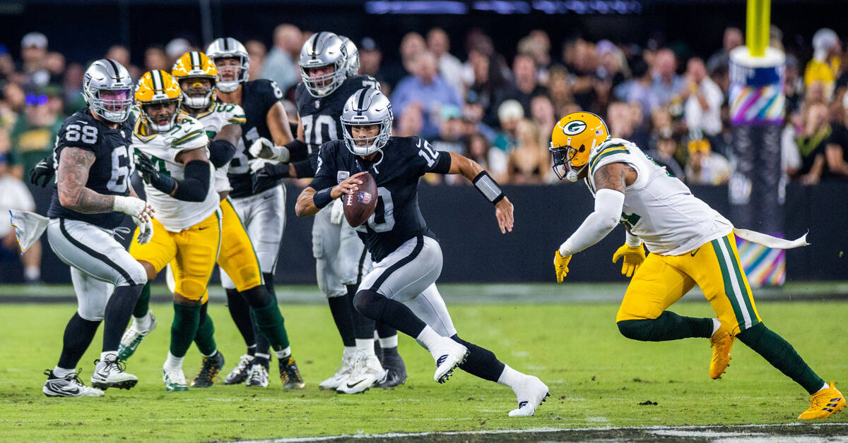 Raiders quarterback Jimmy Garoppolo (10) looks for yards on a run against the Green Bay Packers ...