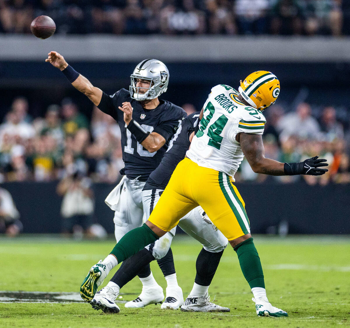 Raiders quarterback Jimmy Garoppolo (10) gets off a pass with a rush by Green Bay Packers defen ...