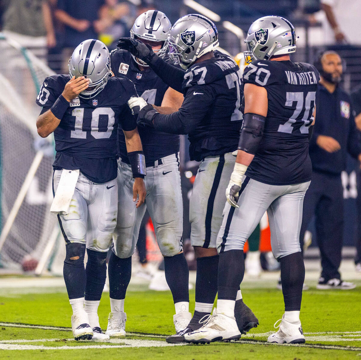 Raiders quarterback Jimmy Garoppolo (10) is checked on by teammates after a hard sack from the ...