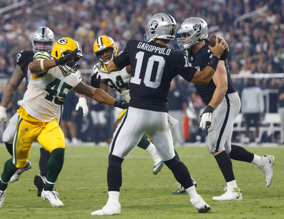 Raiders quarterback Jimmy Garoppolo (10) throws a pass under pressure from the Green Bay Packer ...