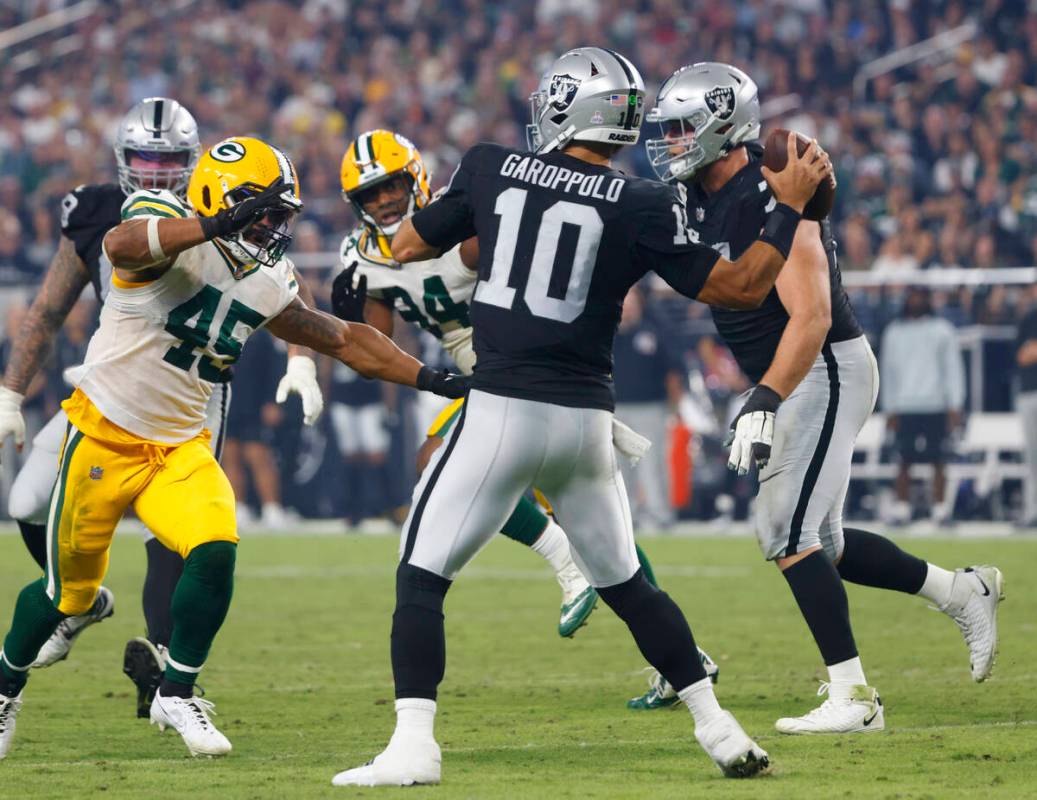 Raiders quarterback Jimmy Garoppolo (10) throws a pass under pressure from the Green Bay Packer ...