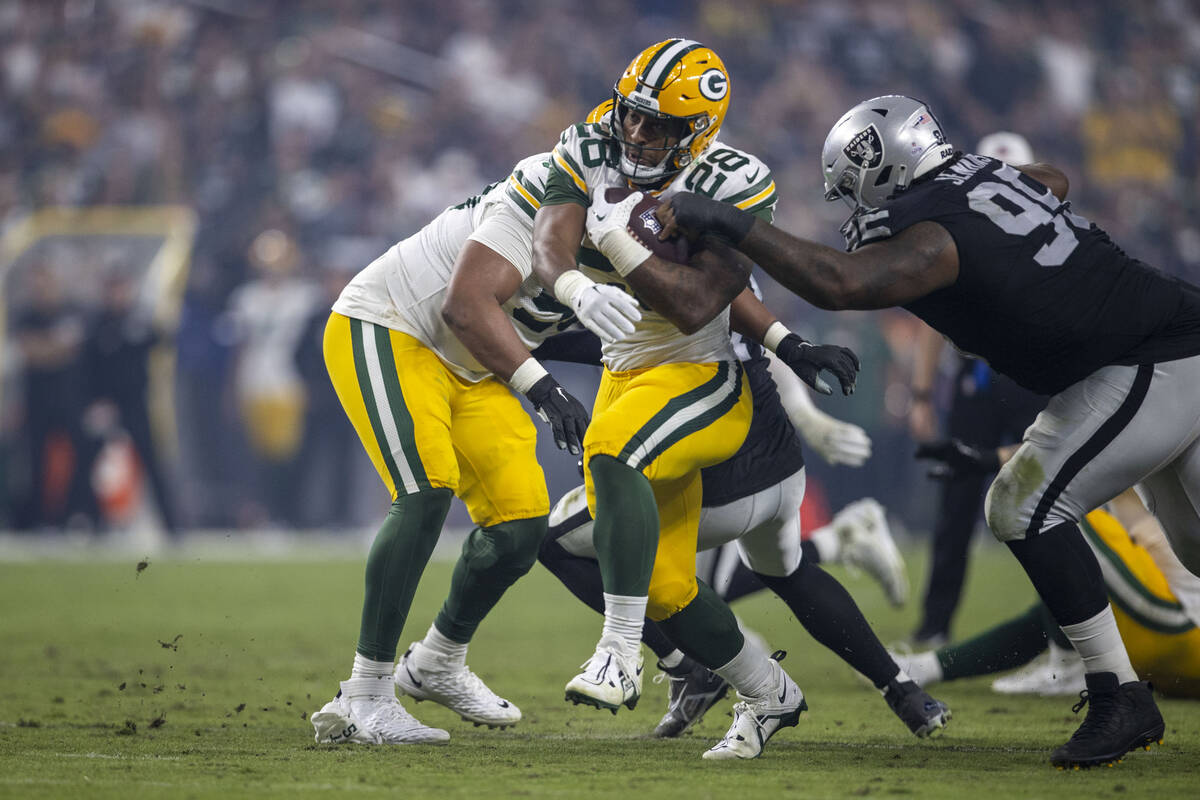 Green Bay Packers running back AJ Dillon (28) tries to run past Raiders defensive tackle John J ...