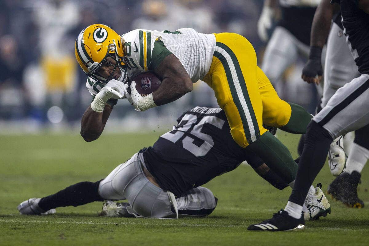 Green Bay Packers running back AJ Dillon (28) is tackled by Raiders defensive tackle John Jenki ...