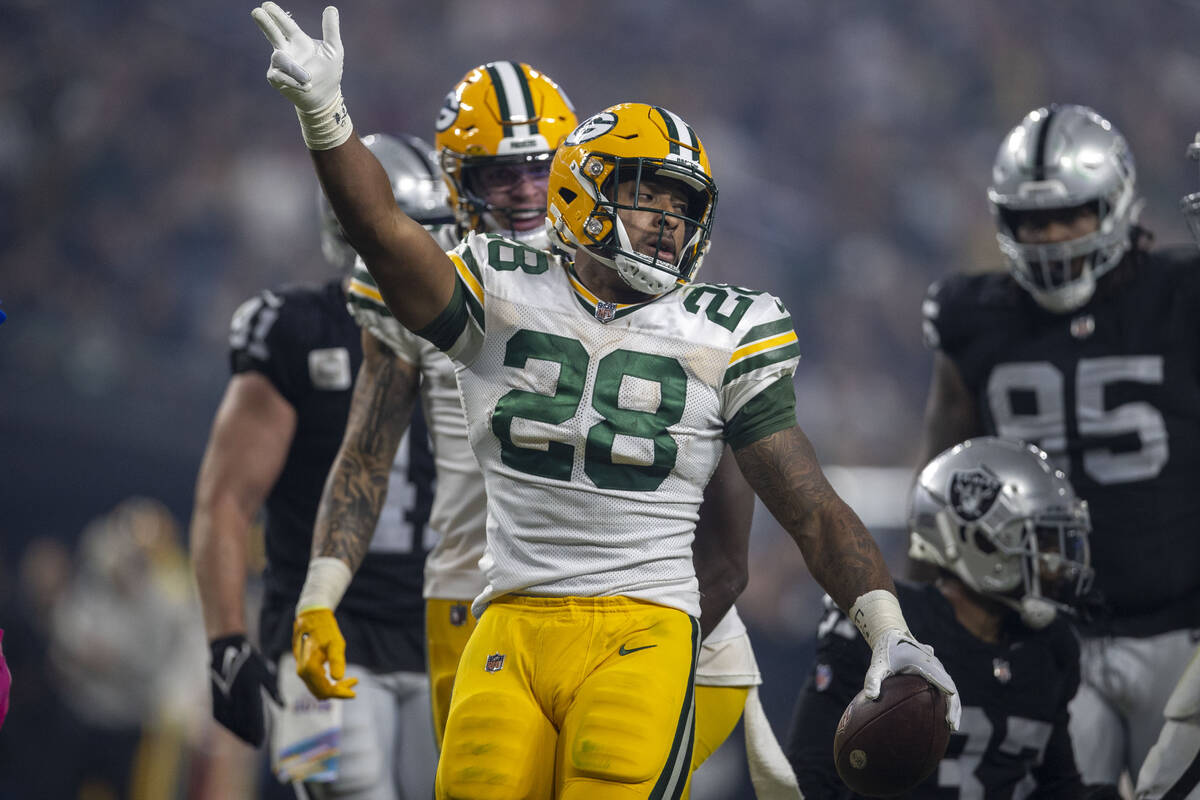 Green Bay Packers running back AJ Dillon (28) signals for a first down against the Raiders duri ...