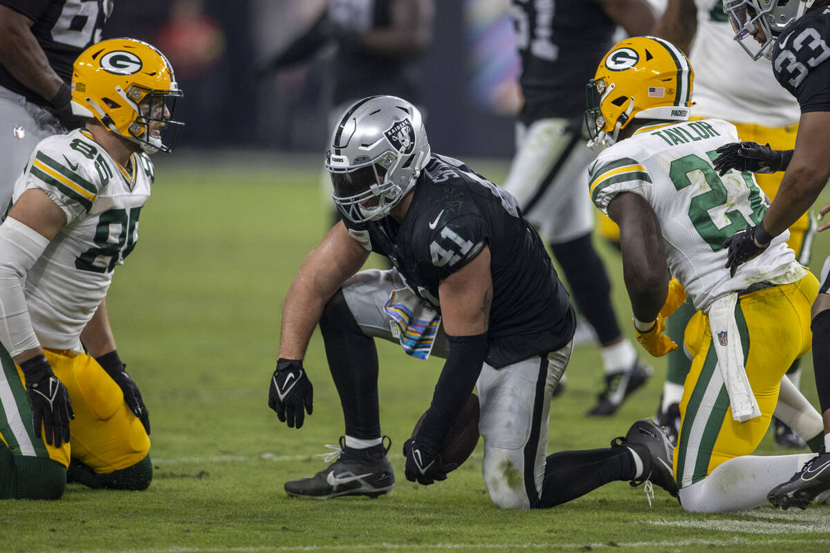 Raiders linebacker Robert Spillane (41) holds on to the football after an interception as Green ...