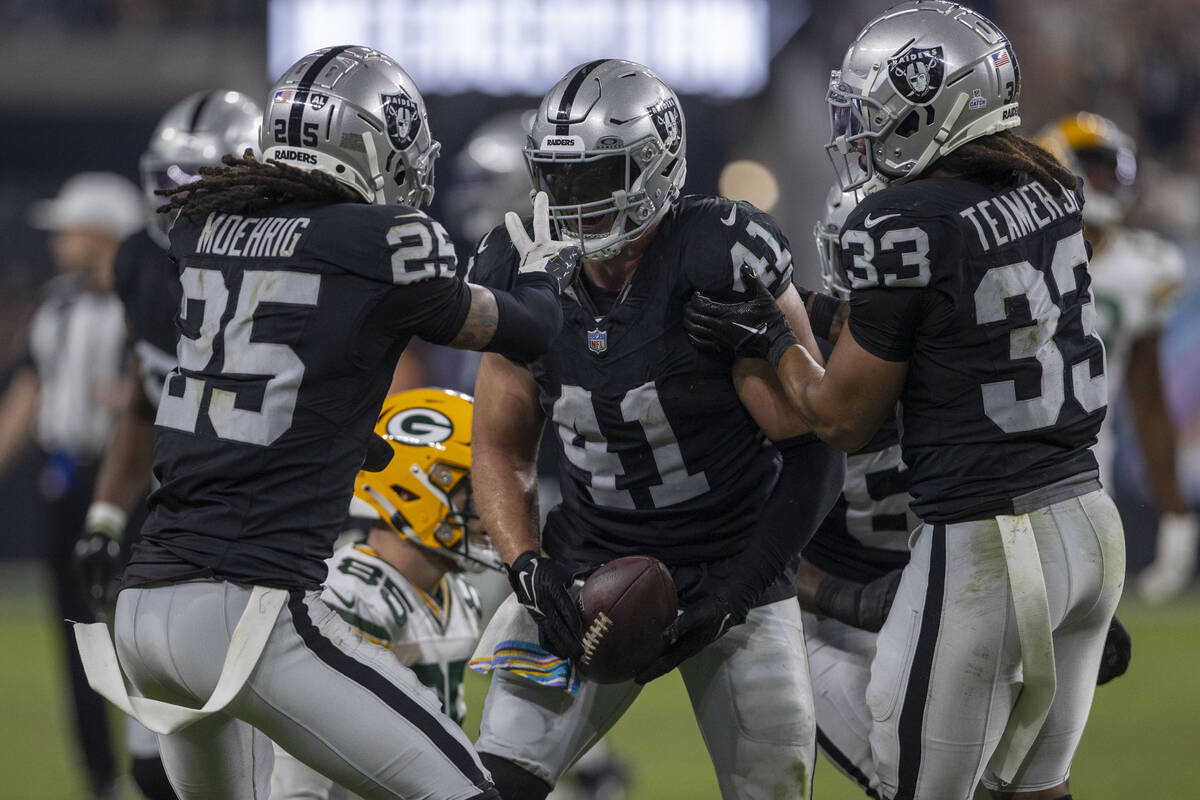 Raiders safety Tre'von Moehrig (25) and safety Roderic Teamer (33) congratulate linebacker Robe ...