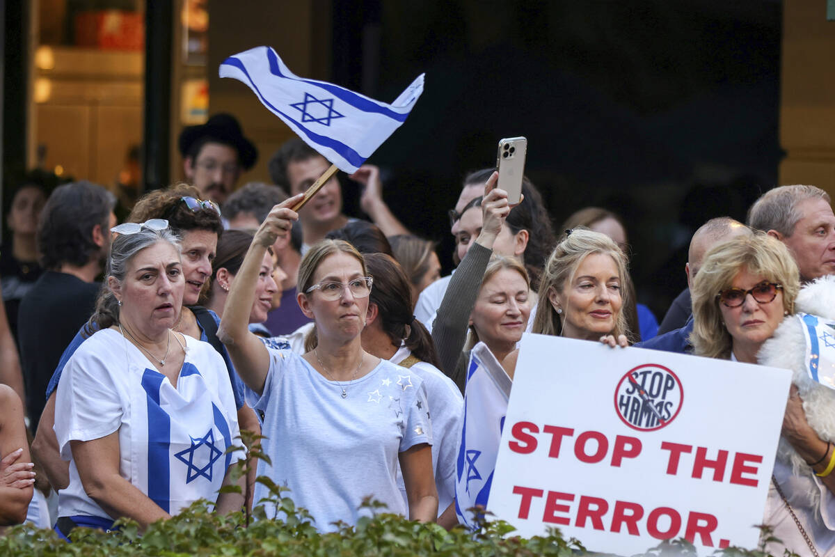Attendees wave flags and hold signs alongside members of the South Florida Jewish community and ...