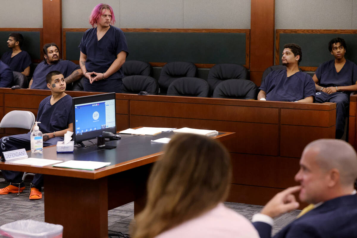 Jesus Ayala, 18, seated lower left, and Jzamir Keys, 16, right rear, wait to appear in court at ...