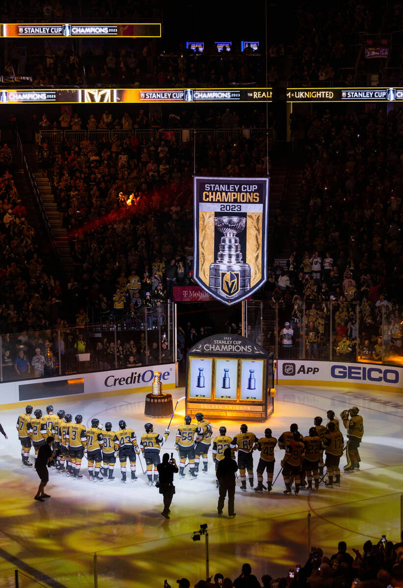 Golden Knights players gather during the raising of the 2023 Stanley Cup Championship banner be ...