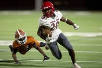 Arbor View running back Kamareion Bell (20) carries the ball through an attempted tackle by Leg ...