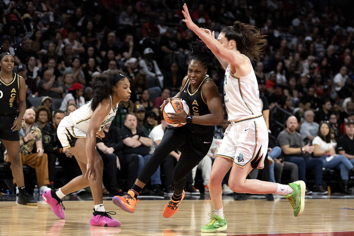 Las Vegas Aces guard Chelsea Gray (12) drives between New York Liberty forward Betnijah Laney ( ...