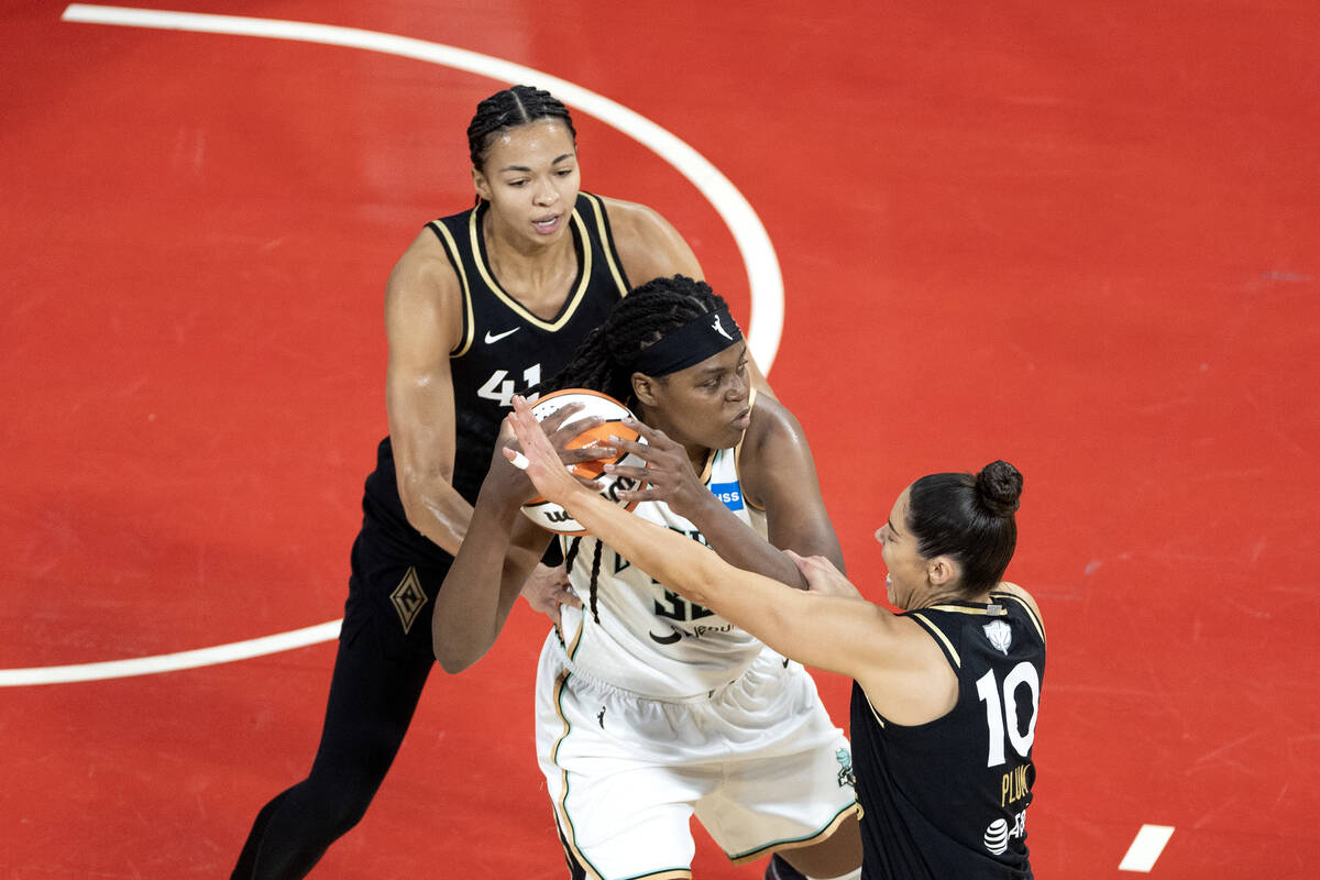 Las Vegas Aces center Kiah Stokes (41) and guard Kelsey Plum (10) surround New York Liberty for ...