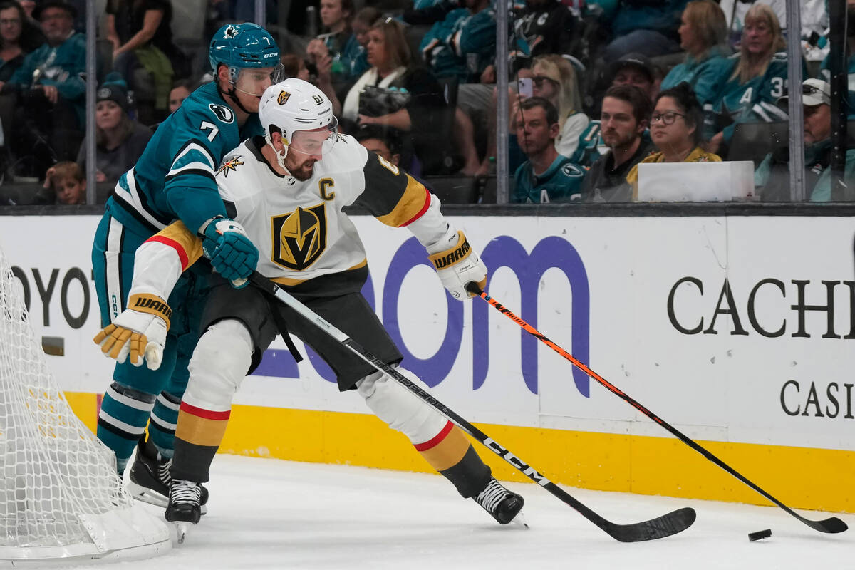 Vegas Golden Knights right wing Mark Stone, right, reaches for the puck in front of San Jose Sh ...