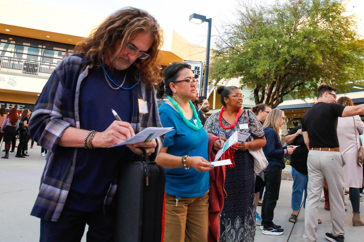 People work together to solve a puzzle at a launch event for the Nevada Department of Education ...