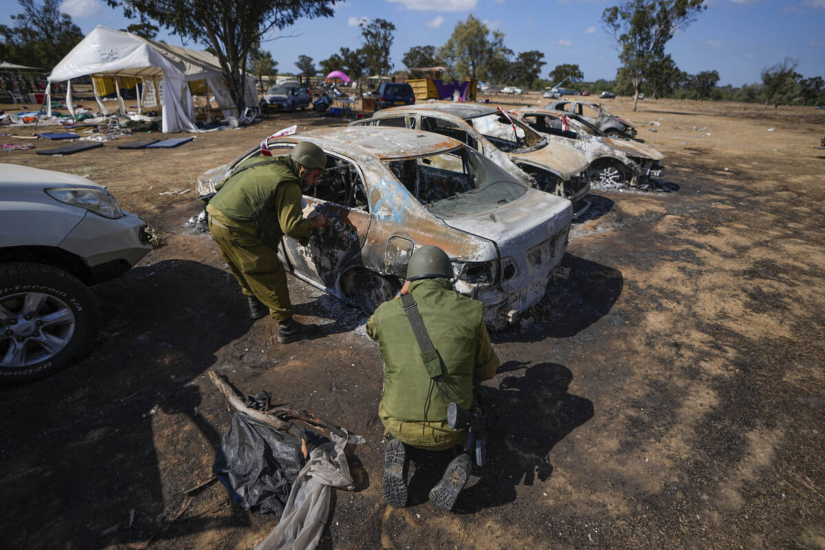Israeli soldiers inspect the site of a music festival near the border with the Gaza Strip in so ...