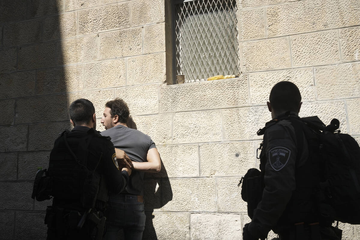 Israeli policeman detains a Palestinian in the Old City in Jerusalem, Friday, Oct. 13, 2023. (A ...