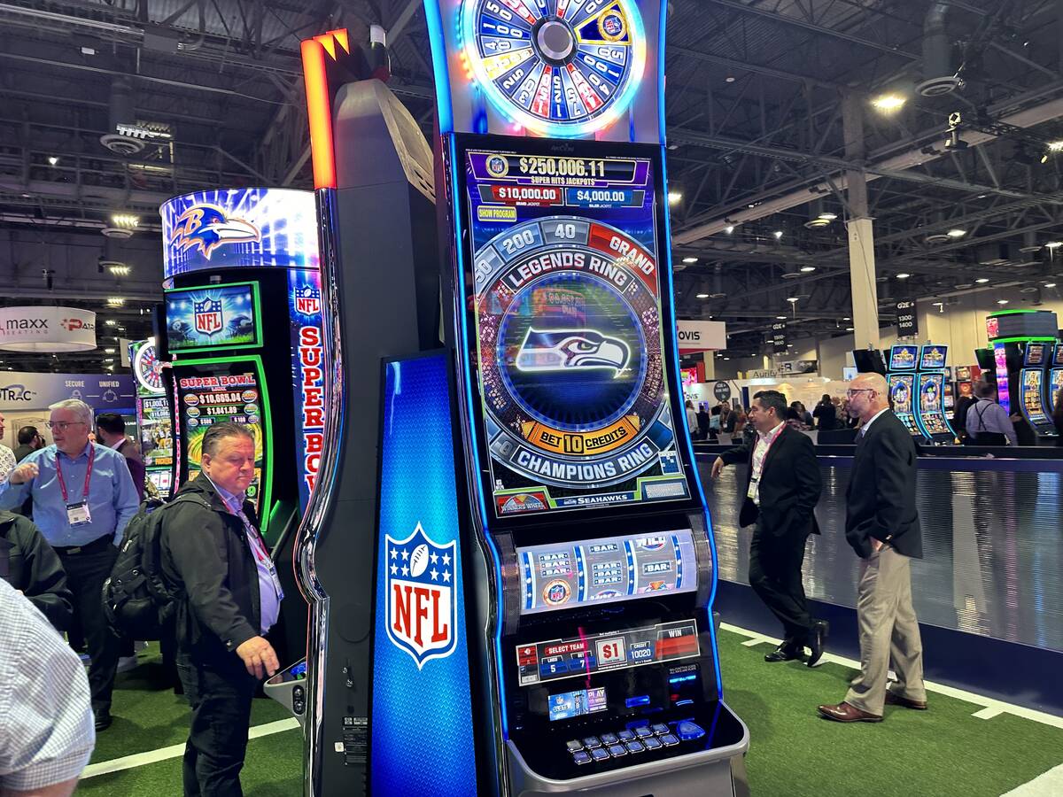NFL-themed slot machines being played by attendees at Aristocrat Gaming's booth at the Global G ...
