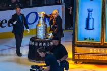 The keeper of the cup takes it away following the raising of the 2023 Stanley Cup Championship ...