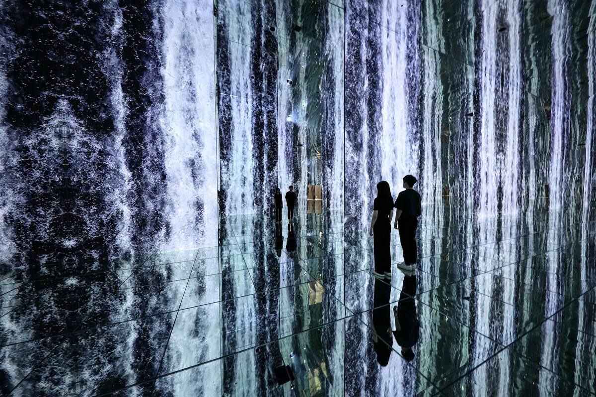 Guests look at the waterfall scene at Arte Museum. The digital projection attraction is set to ...