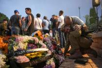 Friends and relatives of Ilai Bar Sade mourn next to his grave during his funeral at the milita ...