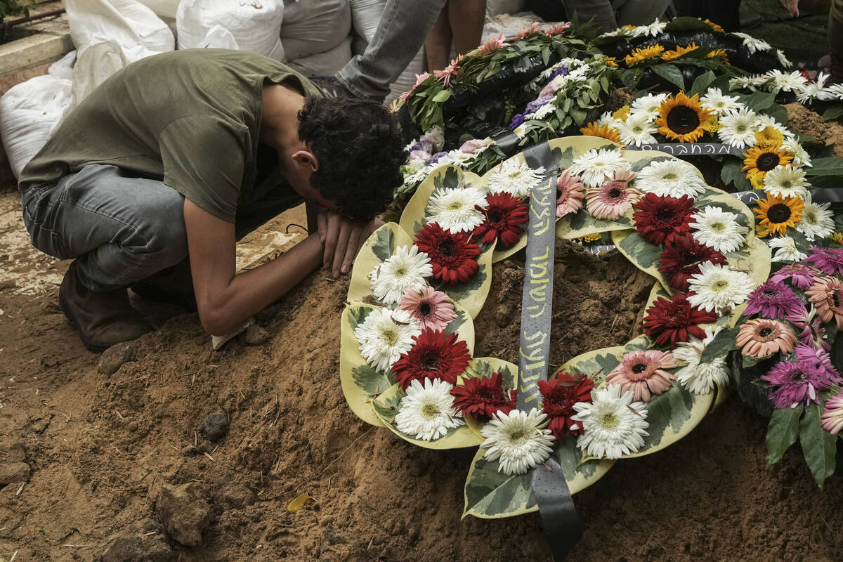 FILE - A man mourns during the funeral of Israeli Col. Roi Levy at the Mount Herzl cemetery in ...