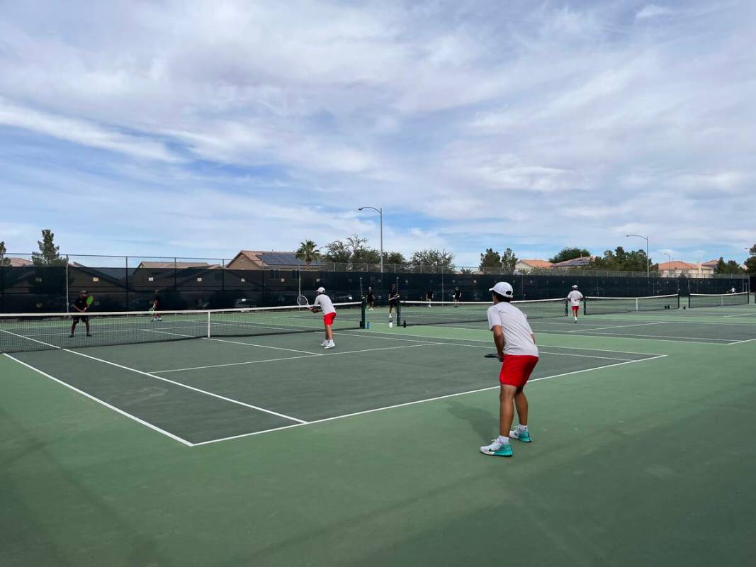 The boys doubles teams from Palo Verde (black shirts) and Coronado (gray shirts) play a match d ...