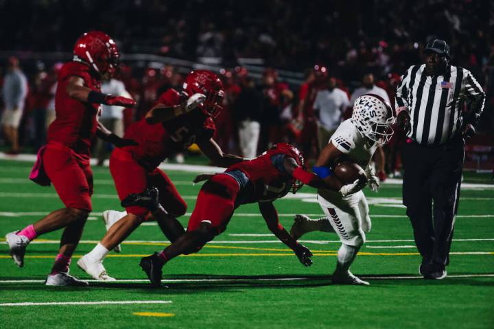Liberty running back Isaiah Lauofo (3) runs the ball past Arbor View defenders during a game at ...