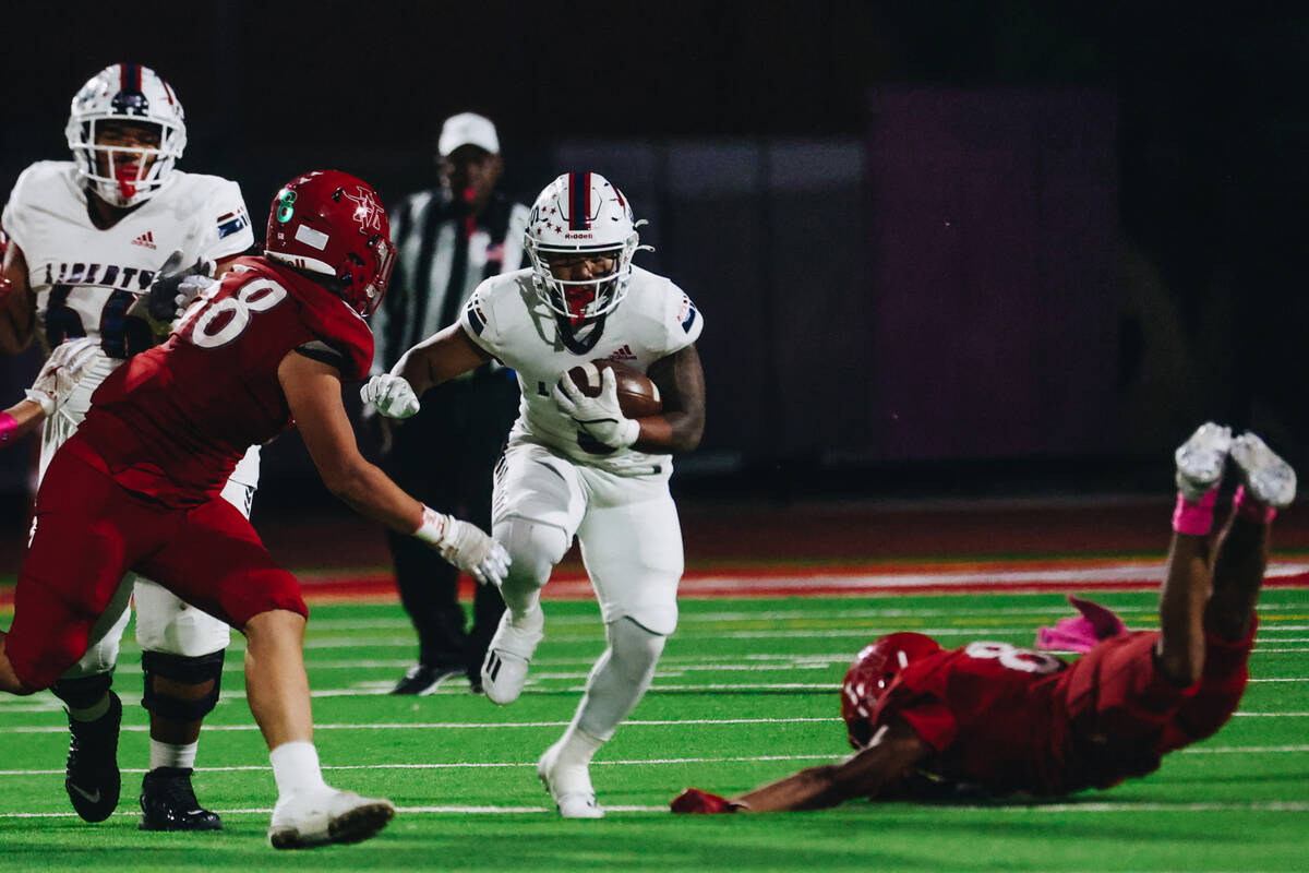 Liberty running back Isaiah Lauofo (3) runs the ball past Arbor View defenders during a game at ...