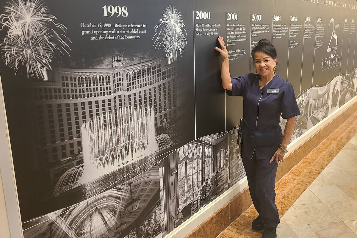 Susan Pegee, one of Bellagio's 1,221 Day 1 employees, poses with a timeline of the resort's his ...