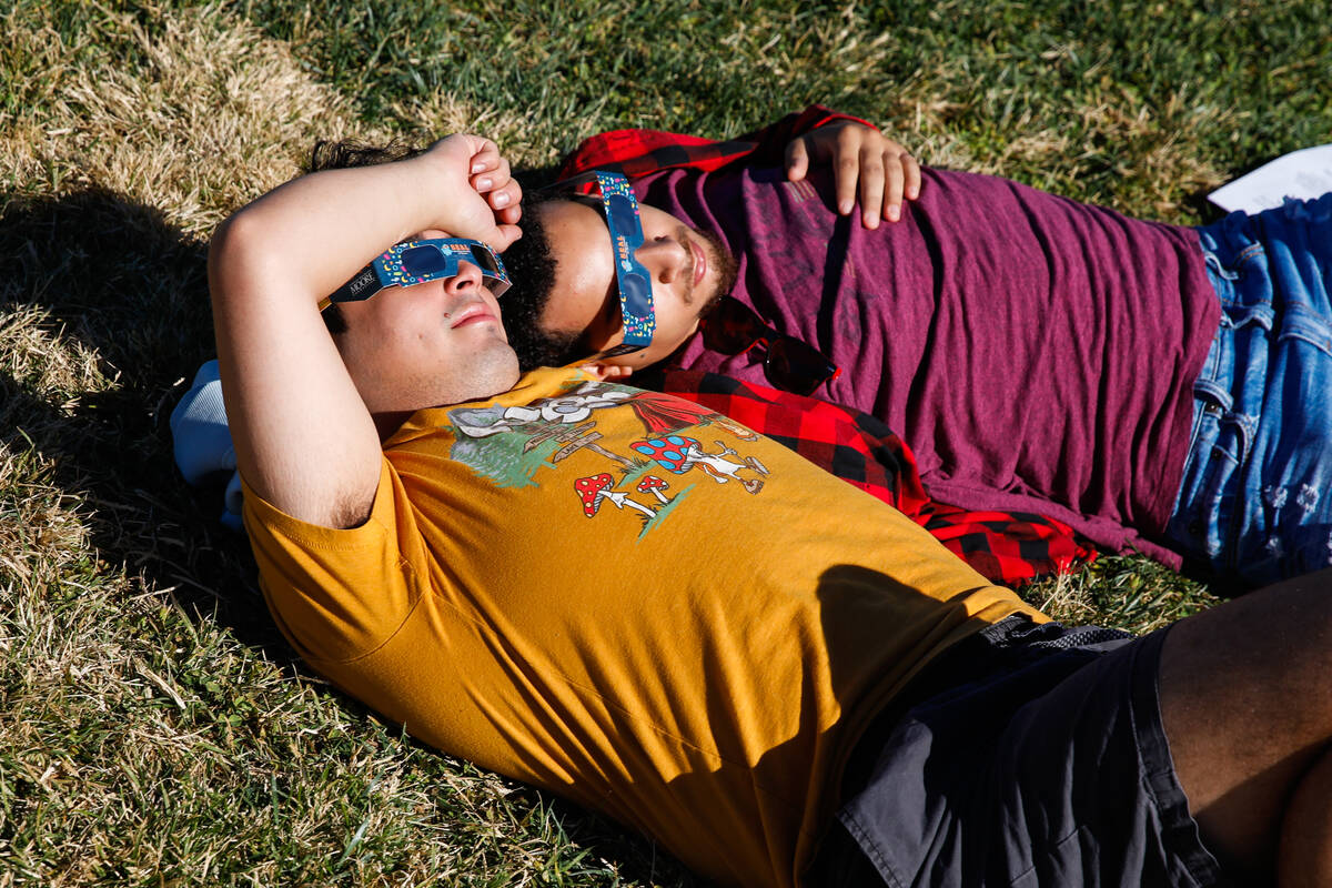 Omar Yanes, left, and Anthoney Olson watch the annular solar eclipse as it passes over Las Vega ...